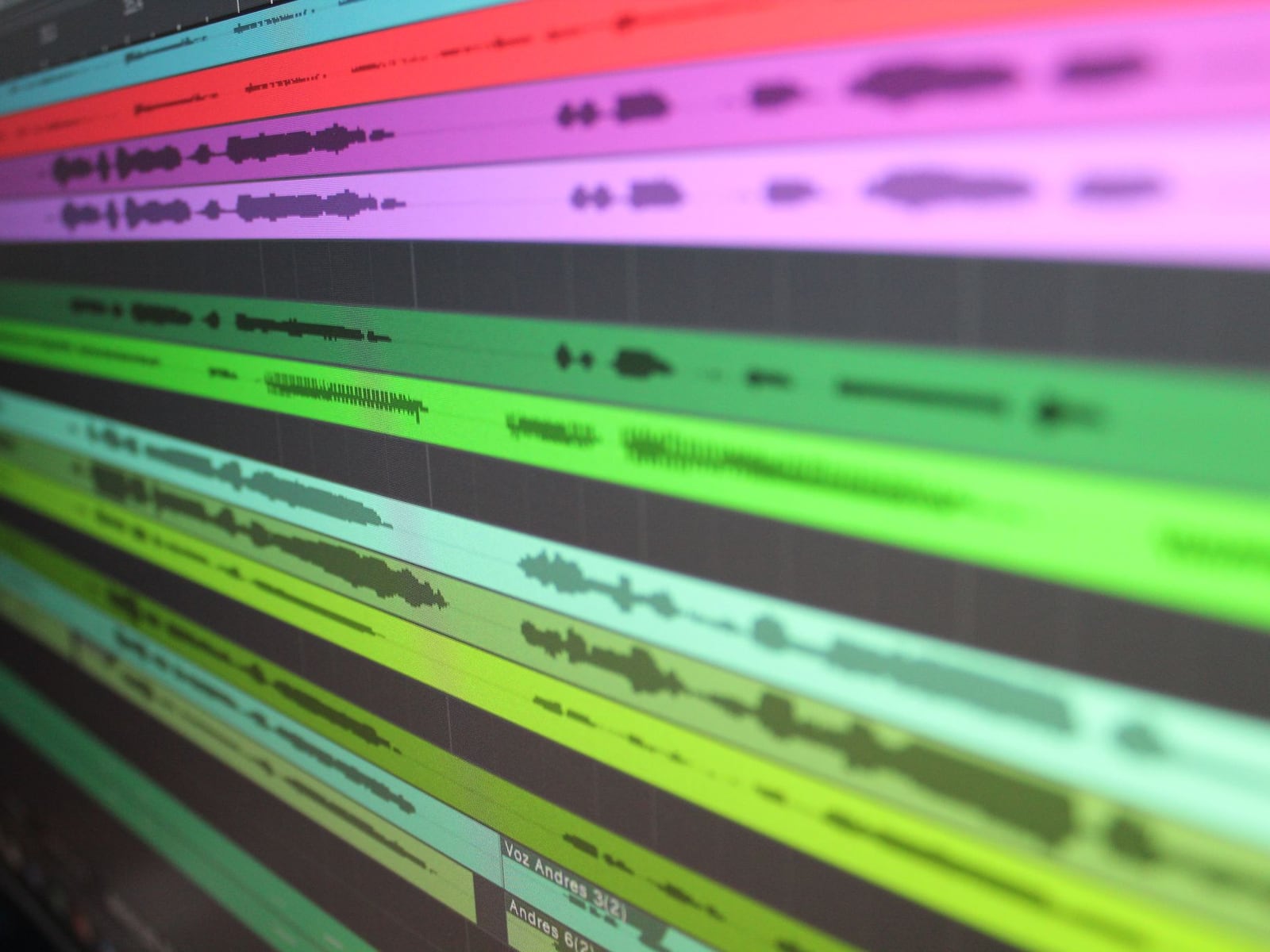 A dual-monitor studio setup displaying multiple audio stems for professional mastering.